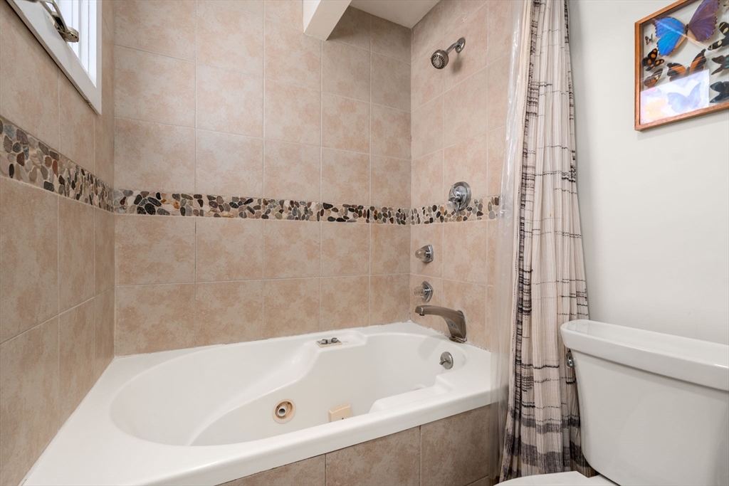 25 Perry Street, Unit 25 Somerville, MA 02143 - Photo 13 of 29 a bathroom with a bathtub and a toilet