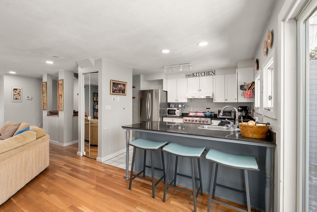 25 Perry Street, Unit 25 Somerville, MA 02143 - Photo 4 of 29 a kitchen with white cabinets and stainless steel appliances