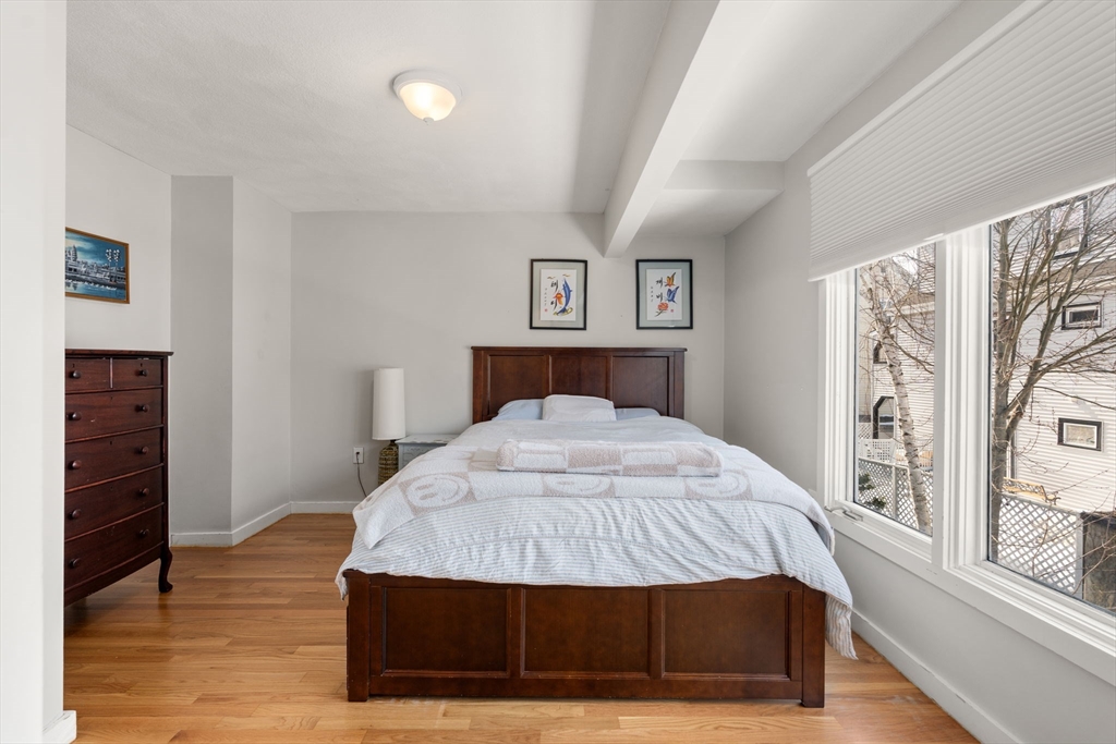 25 Perry Street, Unit 25 Somerville, MA 02143 - Photo 9 of 29 a bedroom with a bed and wooden floor