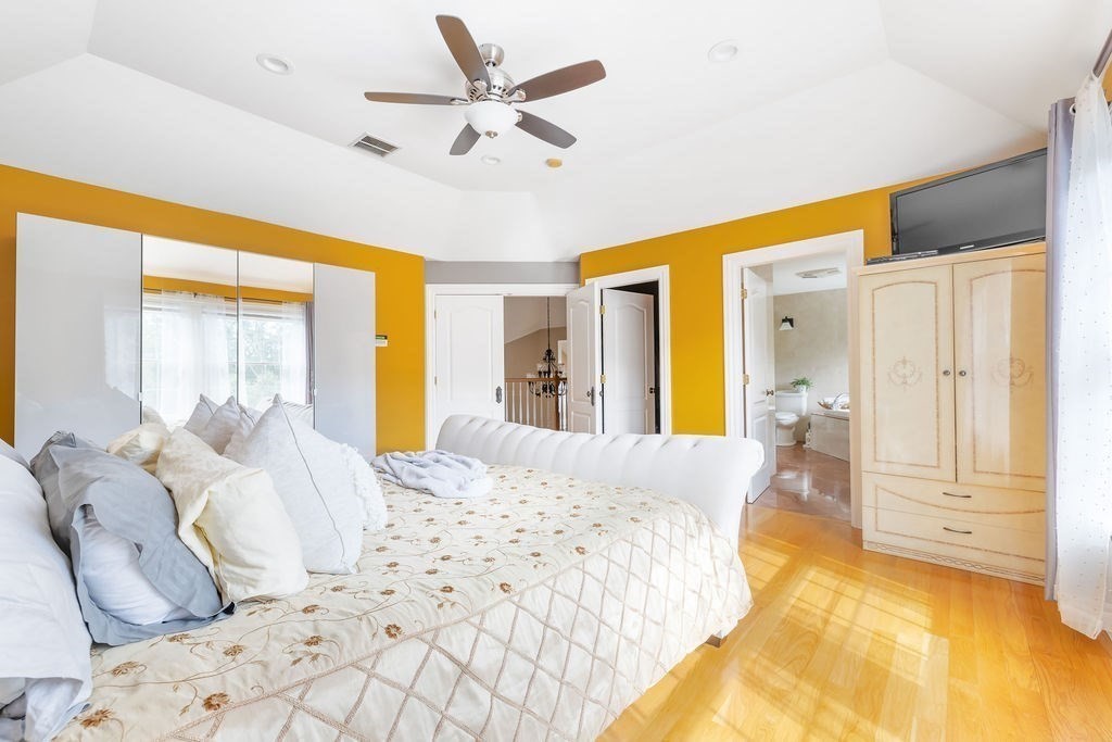 114 Upper Gore Road Webster, MA 01570 - Photo 18 of 40 a spacious bedroom with a large bed and a chandelier