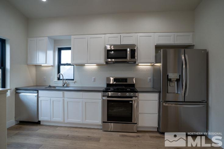 120 Martin Street Reno, NV 89509 - Photo 8 of 14 a kitchen with stainless steel appliances a stove a sink and white cabinets
