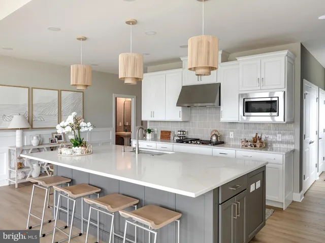 a kitchen with kitchen island granite countertop a sink cabinets and stainless steel appliances