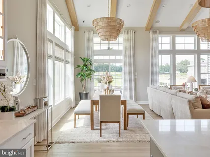 a living room with furniture large window and wooden floor