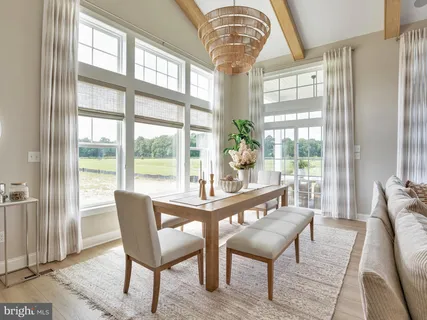a dining room with furniture a chandelier and wooden floor