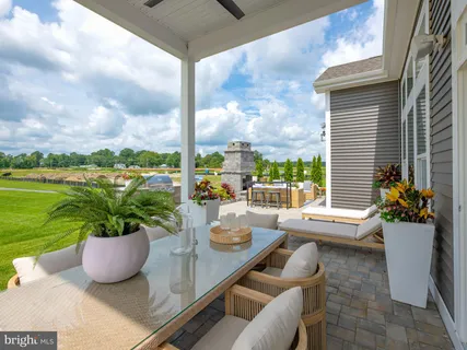 a view of a balcony with chairs and a potted plant