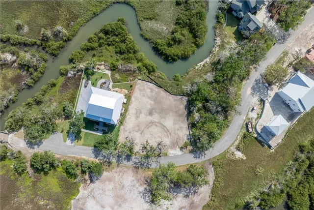 an aerial view of a house with a yard and lake view