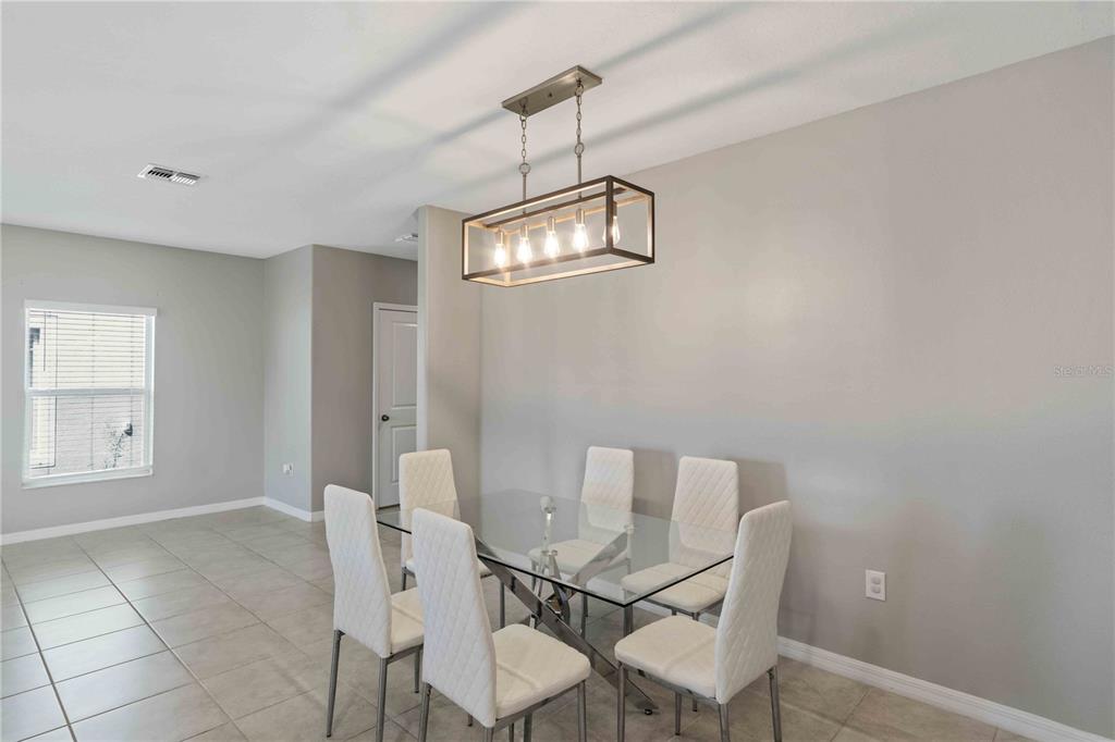 9440 Lemon Drop Loop Sun City Center, FL 33573 - Photo 16 of 55 a view of a dining room with furniture and a chandelier fan
