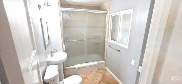 a bathroom with a toilet and a mirror