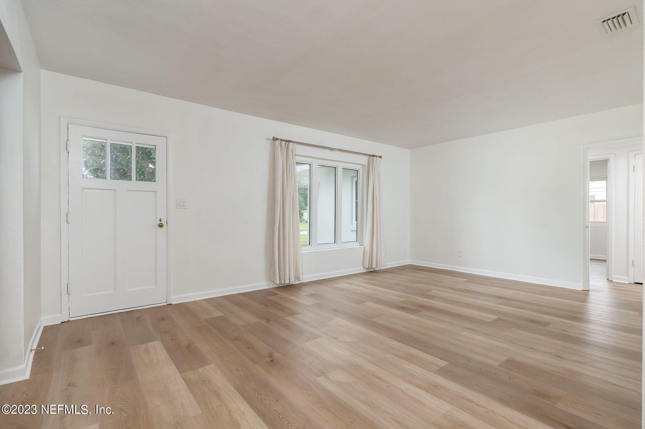 6236 Suwanee Road Jacksonville, FL 32217 - Photo 10 of 38 a view of an empty room with wooden floor and a window