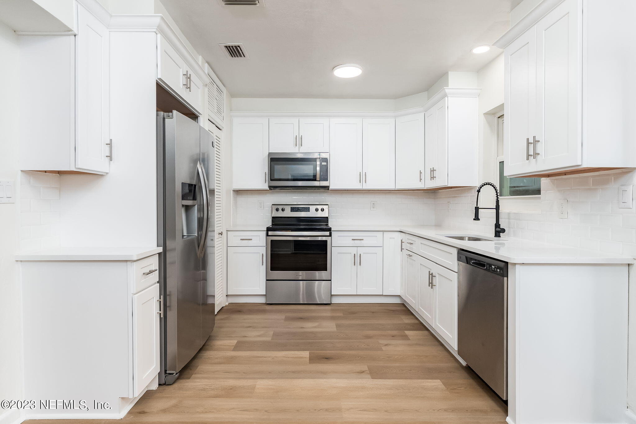 6236 Suwanee Road Jacksonville, FL 32217 - Photo 18 of 38 a kitchen with stainless steel appliances granite countertop a refrigerator sink and white cabinets