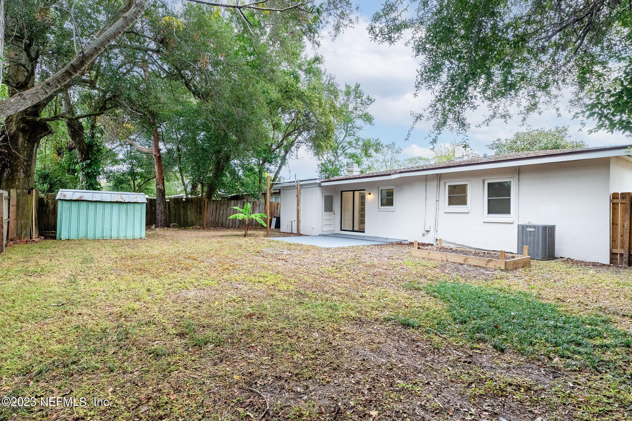 6236 Suwanee Road Jacksonville, FL 32217 - Photo 30 of 38 a backyard of a house with large trees and wooden fence