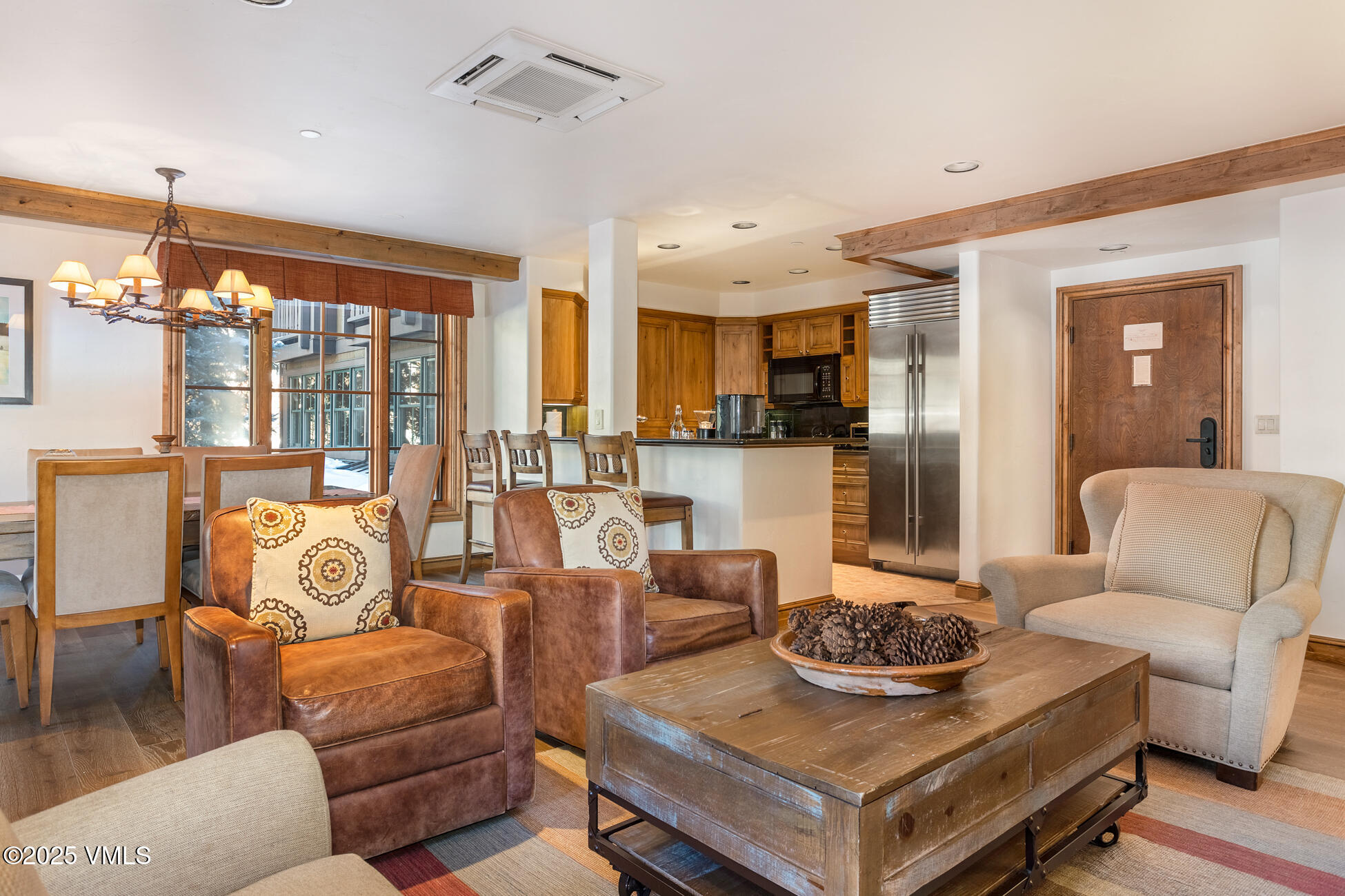 352 East Meadow Drive, Unit J Vail, CO 81657 - Photo 12 of 47 a living room with furniture and a chandelier