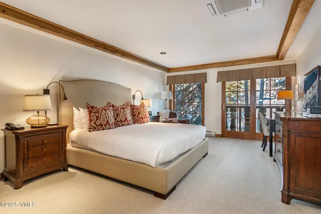 a bedroom with a large bed and a tv