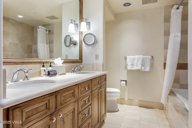 a bathroom with a granite countertop sink a toilet and a mirror
