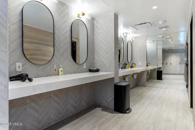 a bathroom with double vanity sinks and a mirror