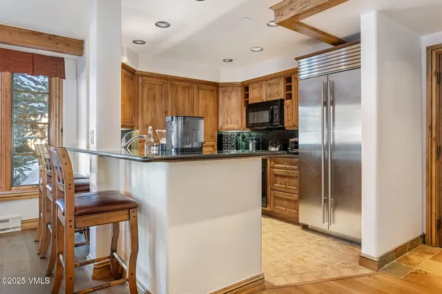 a kitchen with stainless steel appliances granite countertop a refrigerator and a stove top oven