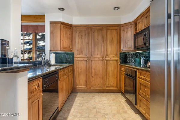 a kitchen with stainless steel appliances granite countertop a refrigerator and a sink