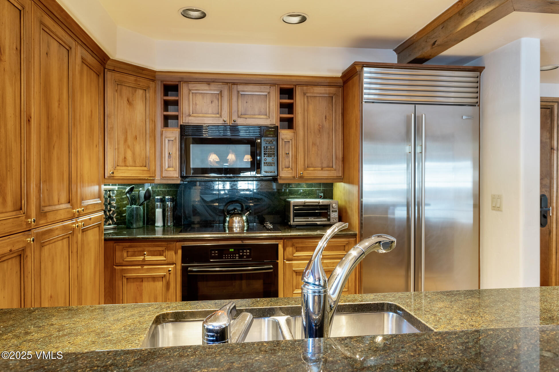 352 East Meadow Drive, Unit J Vail, CO 81657 - Photo 9 of 47 a kitchen with stainless steel appliances granite countertop a refrigerator and a stove top oven