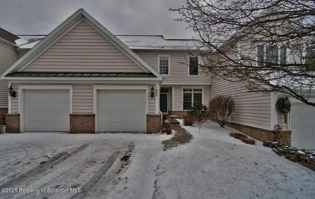 a front view of a house with yard and parking space