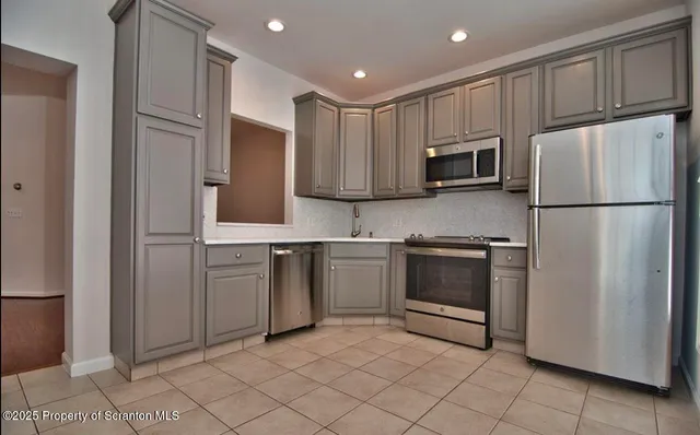 a kitchen with cabinets stainless steel appliances and a counter space
