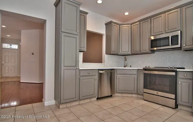 a kitchen with stainless steel appliances granite countertop a refrigerator and a stove top oven