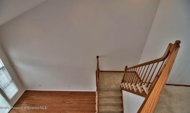 a view of staircase with railing and white walls