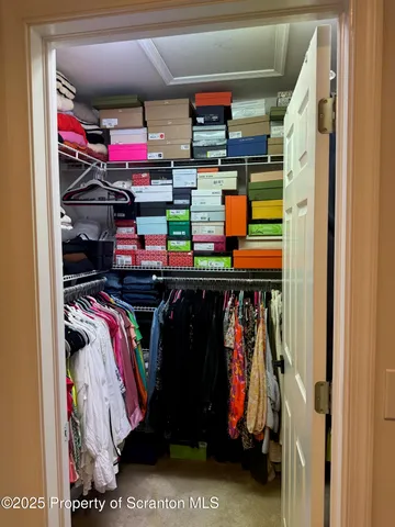 a view of walk in closet with clothes
