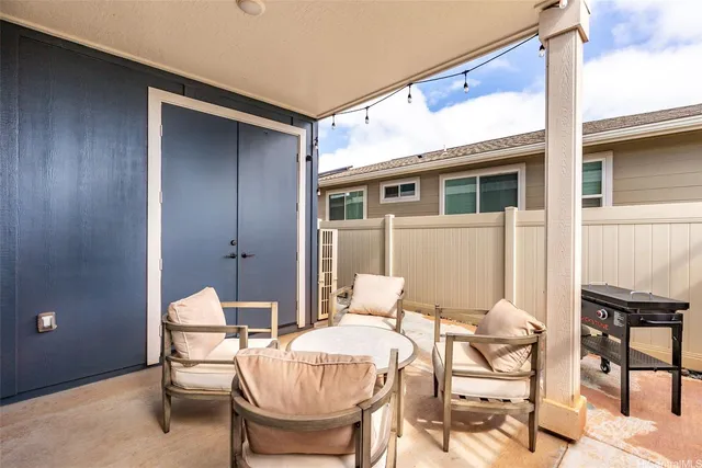 a patio with a table and chairs and potted plants