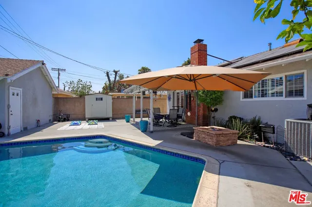 a view of a balcony with chairs and umbrella