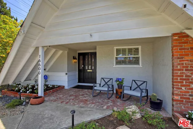 a view of a porch with furniture and floor to ceiling window