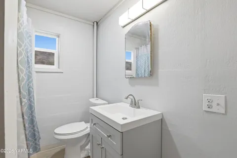a bathroom with a sink toilet and mirror