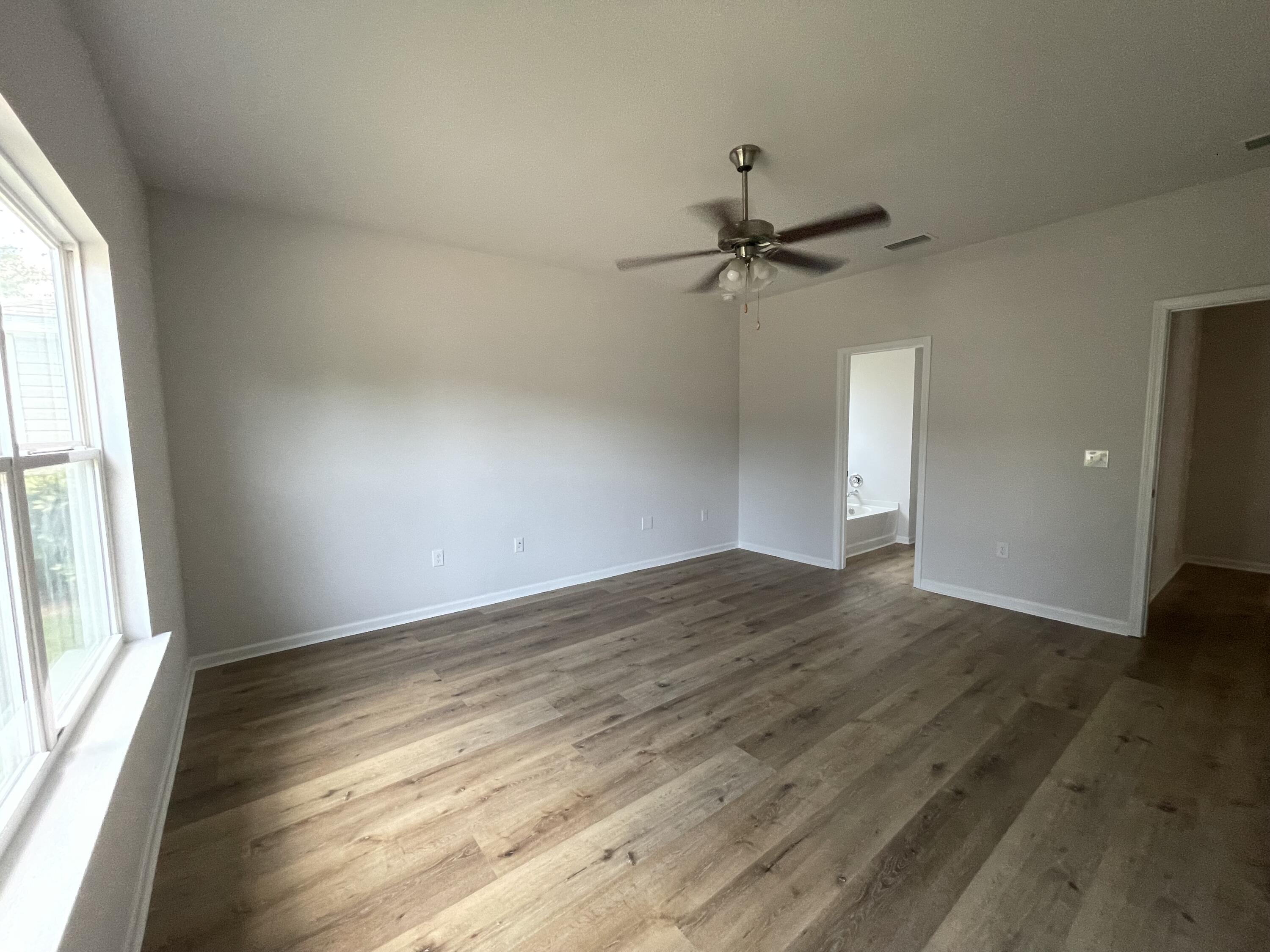 56 Lilly Bell Lane Freeport, FL 32439 - Photo 15 of 20 an empty room with wooden floor fan and windows