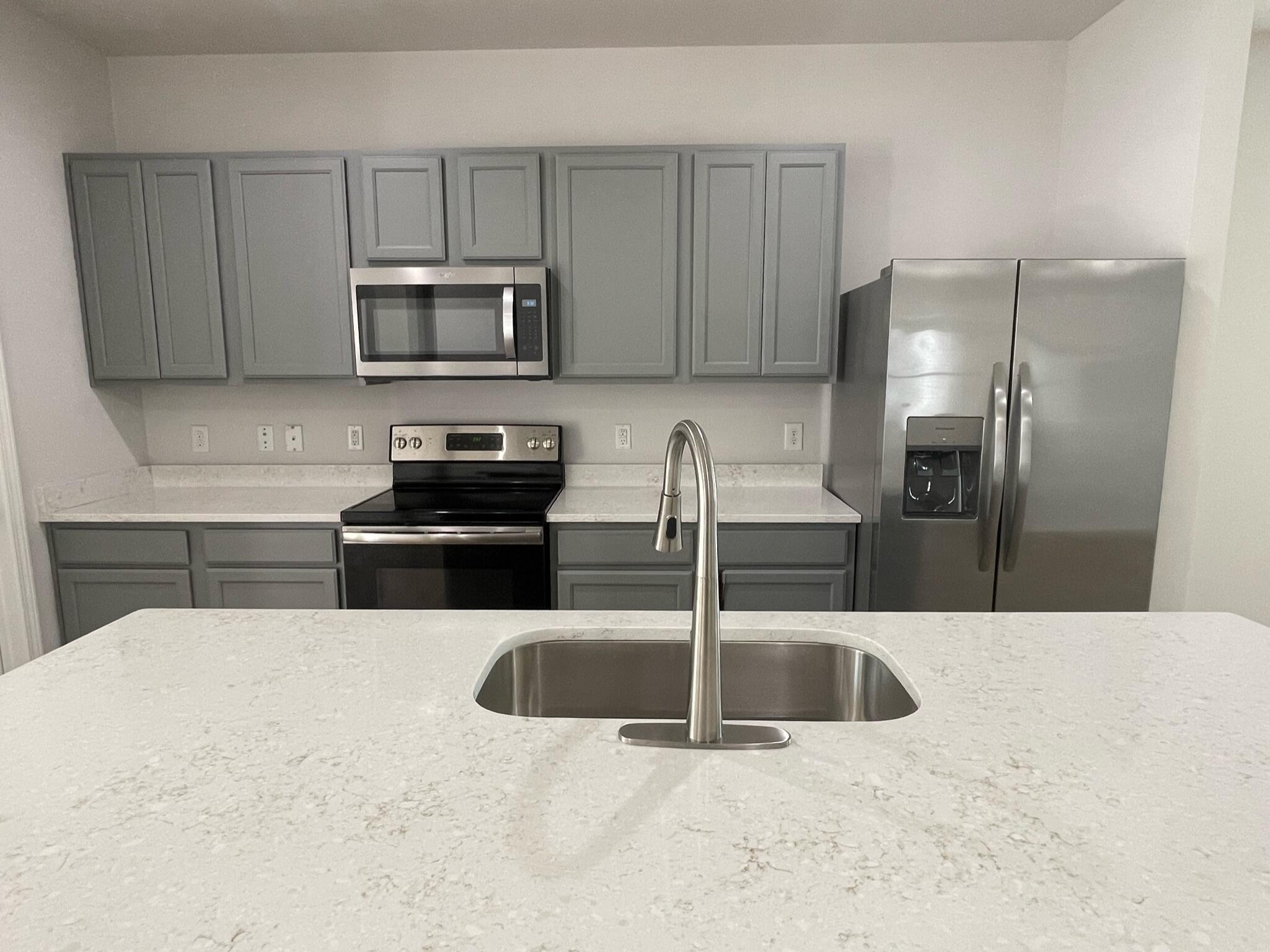 56 Lilly Bell Lane Freeport, FL 32439 - Photo 5 of 20 a kitchen with stainless steel appliances kitchen island granite countertop a refrigerator a sink a stove a microwave and island