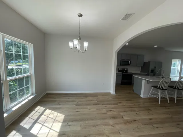 a open kitchen with wooden floor and stainless steel appliances