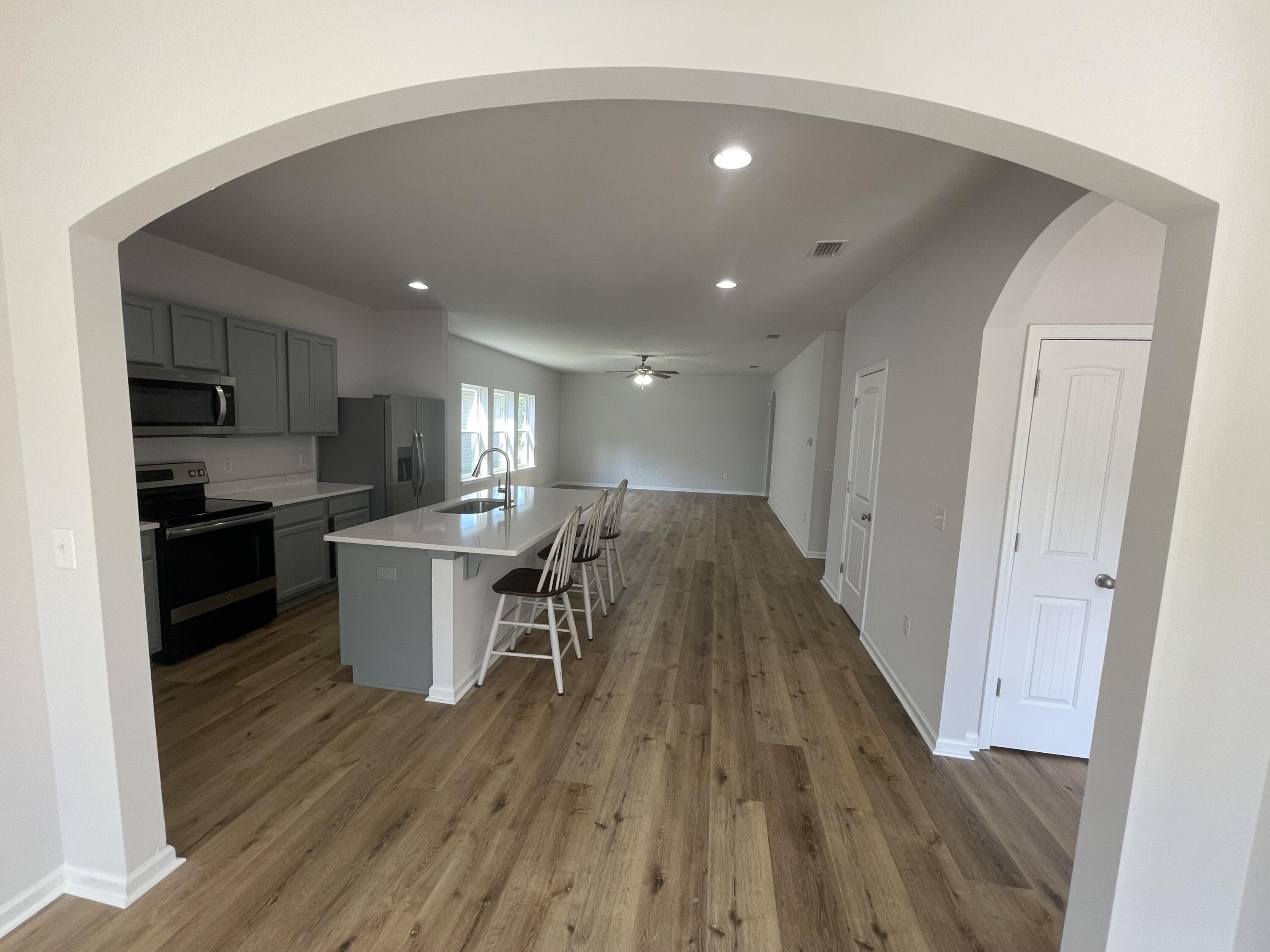 56 Lilly Bell Lane Freeport, FL 32439 - Photo 8 of 20 a open kitchen with wooden floor and stainless steel appliances