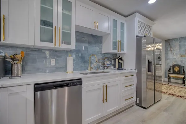a kitchen with stainless steel appliances granite countertop a refrigerator and a sink