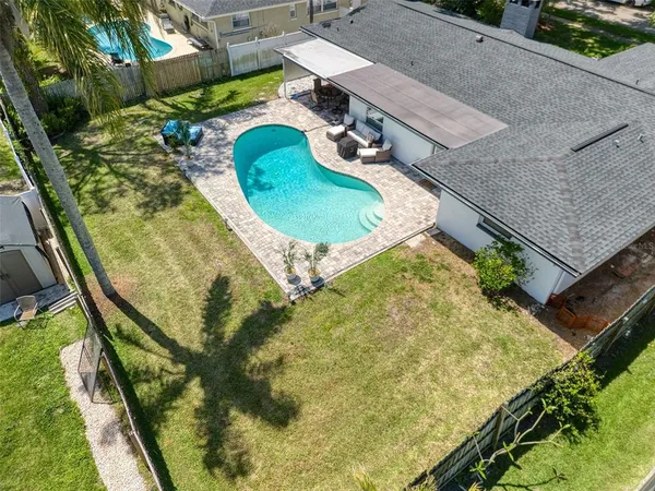 an aerial view of a house with a yard and large trees