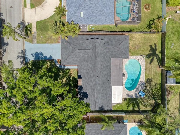 a view of a house with a yard and palm trees