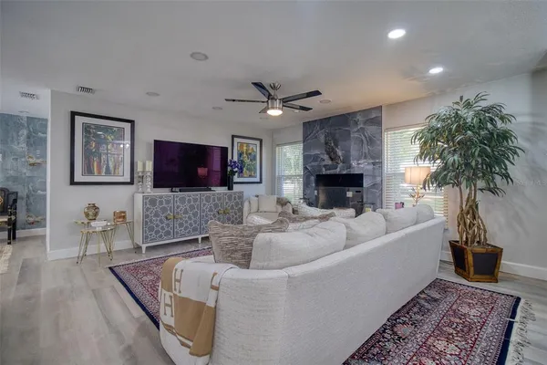 a living room with furniture a fireplace and a flat screen tv