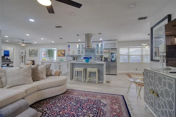 a living room with stainless steel appliances furniture and a rug