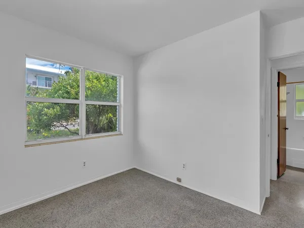 front view of a house with a yard and palm trees
