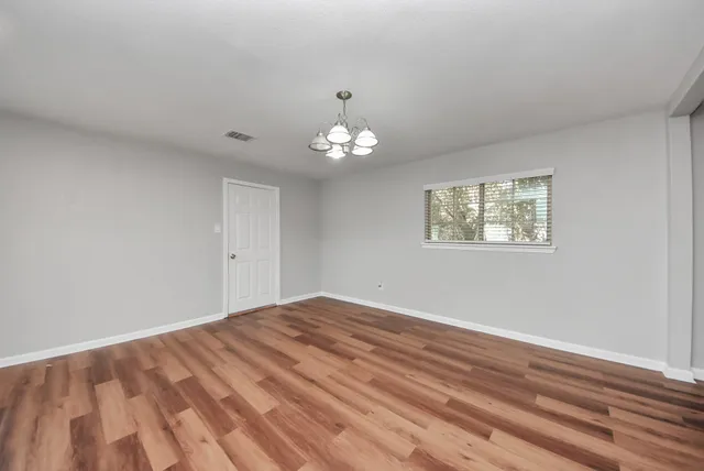 a view of empty room with wooden floor