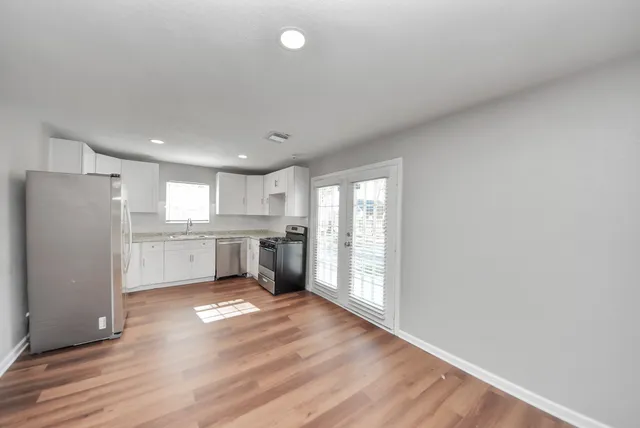 a view of kitchen with wooden floor and electronic appliances