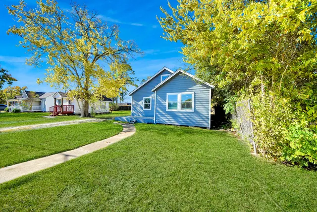 a view of a house with yard and tree s