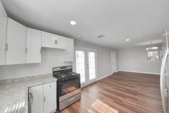 a kitchen with granite countertop a stove and cabinets
