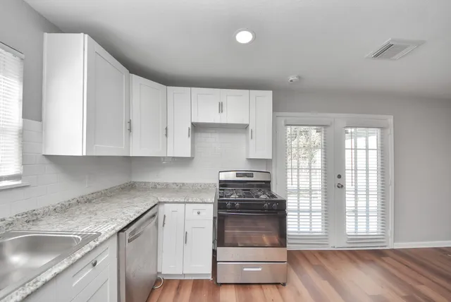 a kitchen with granite countertop white cabinets and appliances