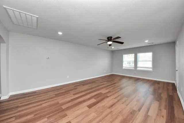 wooden floor in an empty room with a window