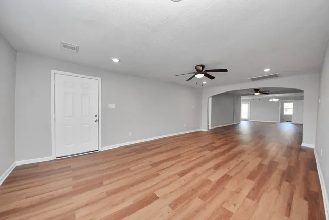 a view of an empty room with wooden floor