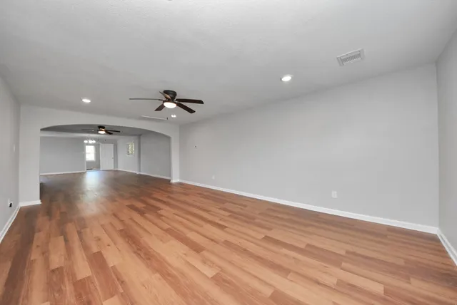 a view of empty room with wooden floor