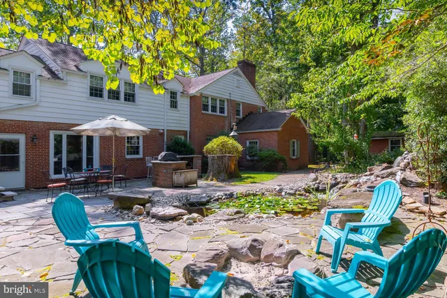 a view of a house with backyard and sitting area